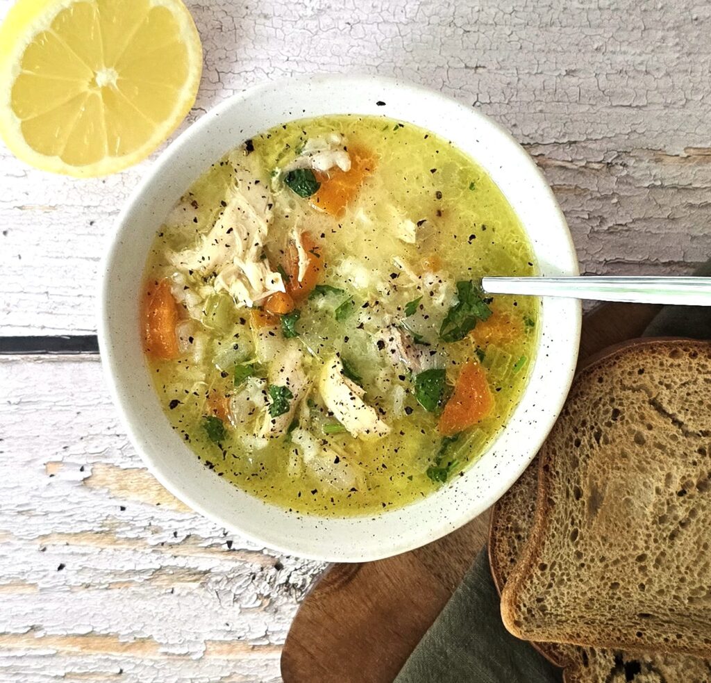 Comforting gluten-free chicken soup ready to serve with fresh parsley and side of toasted gluten-free bread