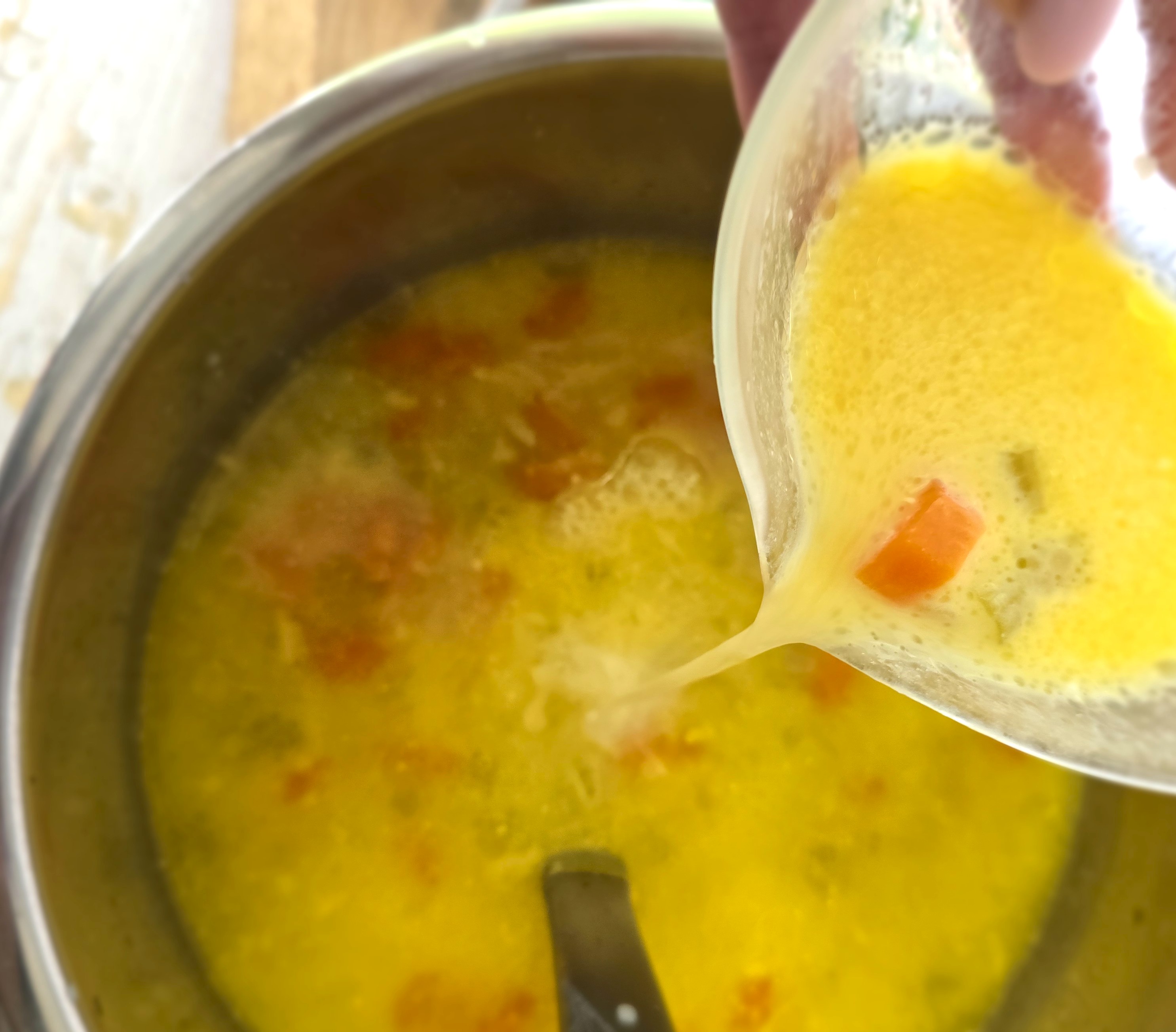 adding the egg yolk yoghurt sauce to the ready warm soup