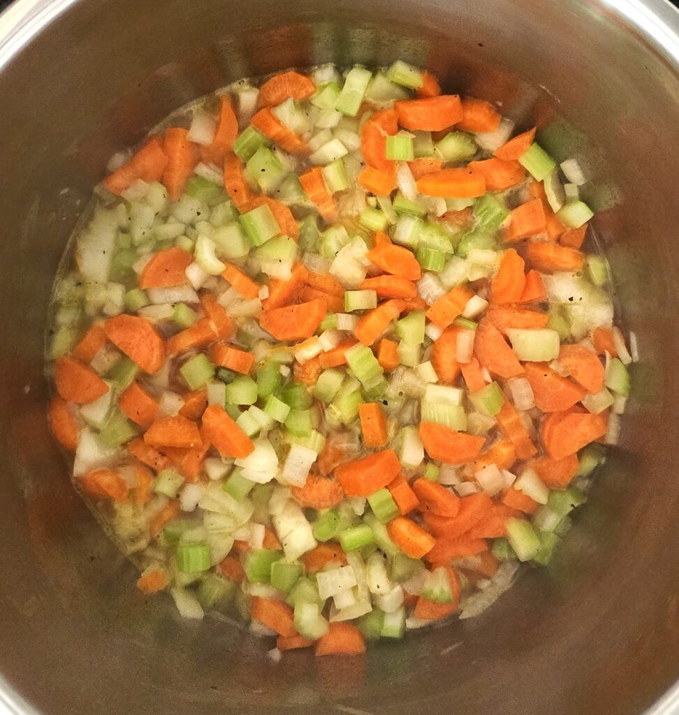 Onions, carrots, and celery root sautéing in oil for soup base