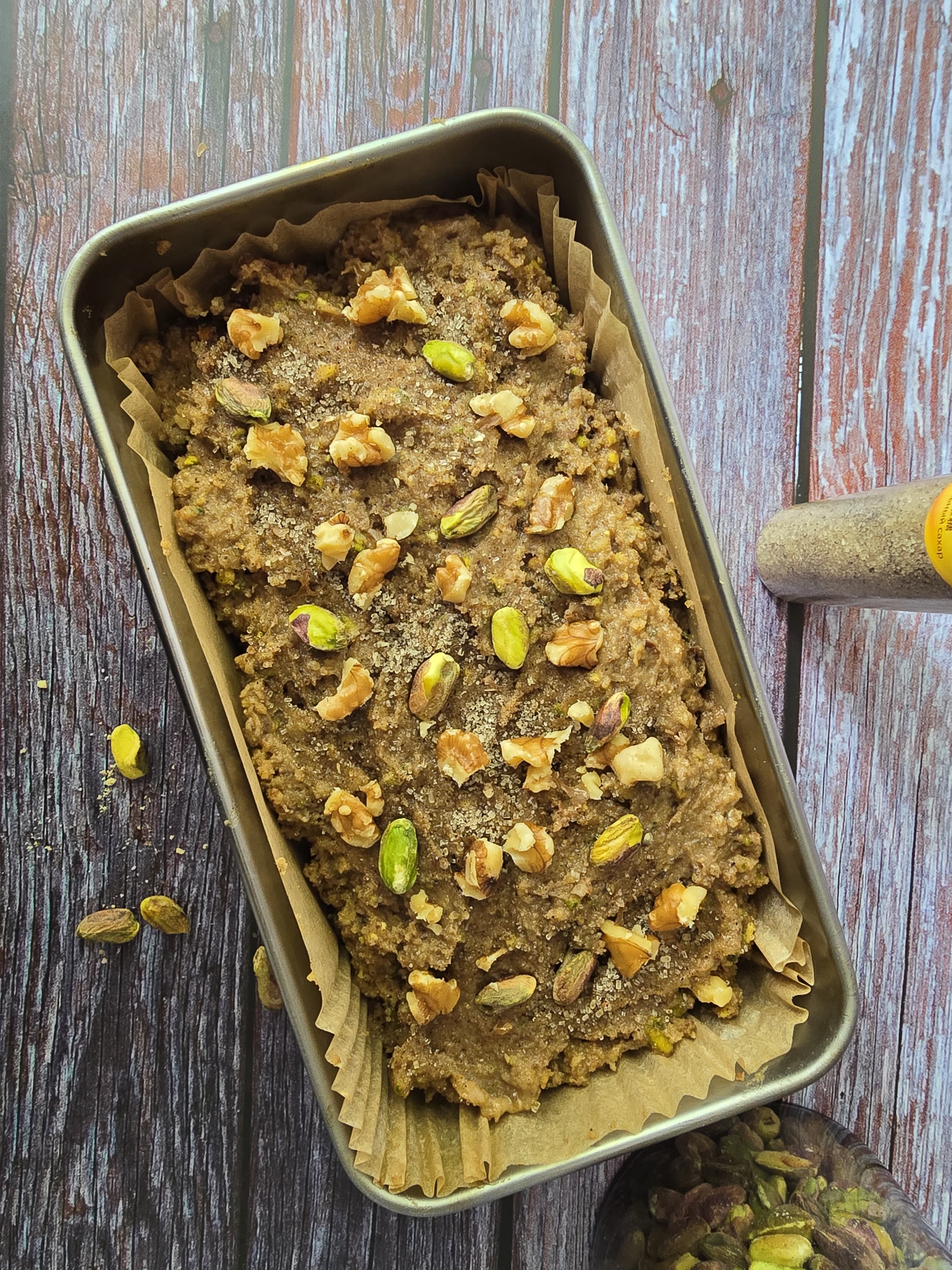 Cake batter poured into a lined round tin, ready for baking.