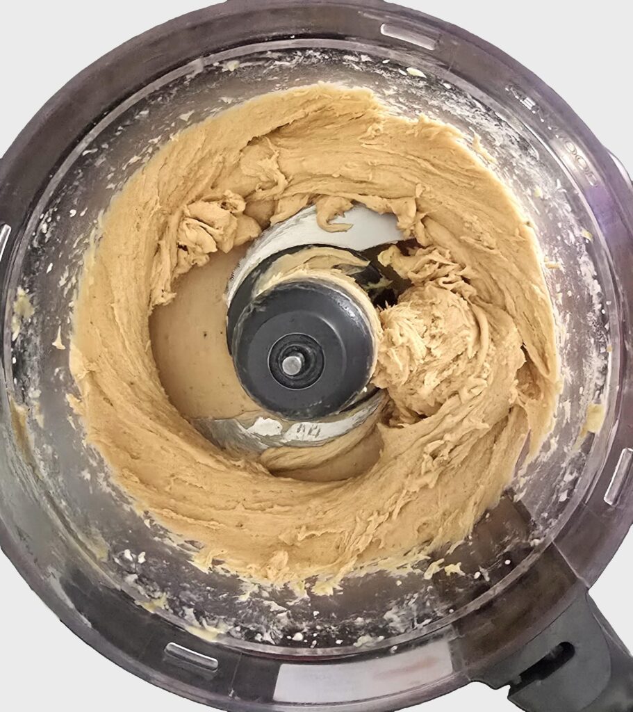 blended mixture of frozen bananas and peanut butter in a food processor