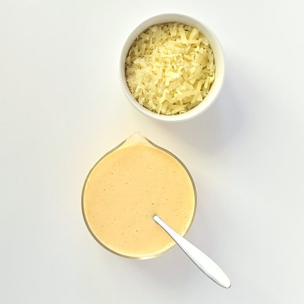 two bowls with beaten eggs, yoghurt and baking soda and grated cheese