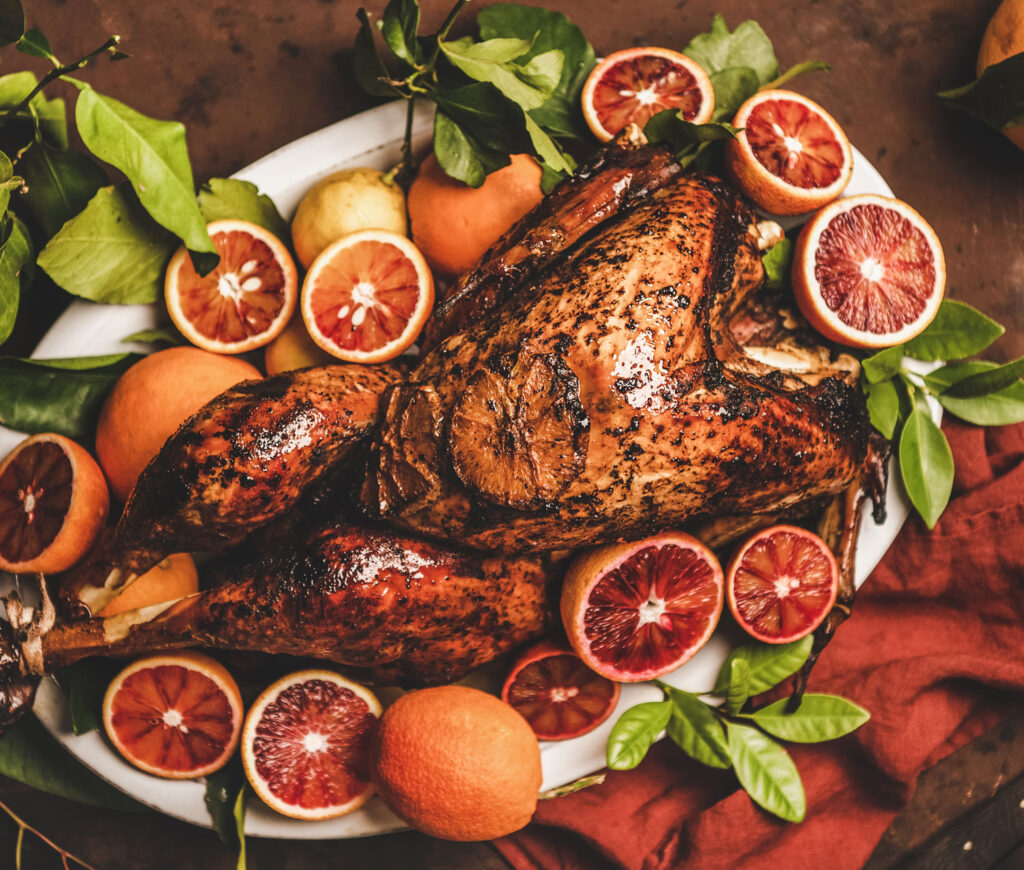 a roasted chicken with blood orange slices with green salad