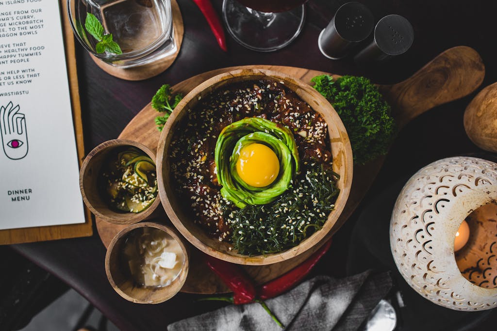 Modern plant-based fusion bowl with avocado, egg yolk, and leafy greens – nourishing gluten-free fusion cuisine idea