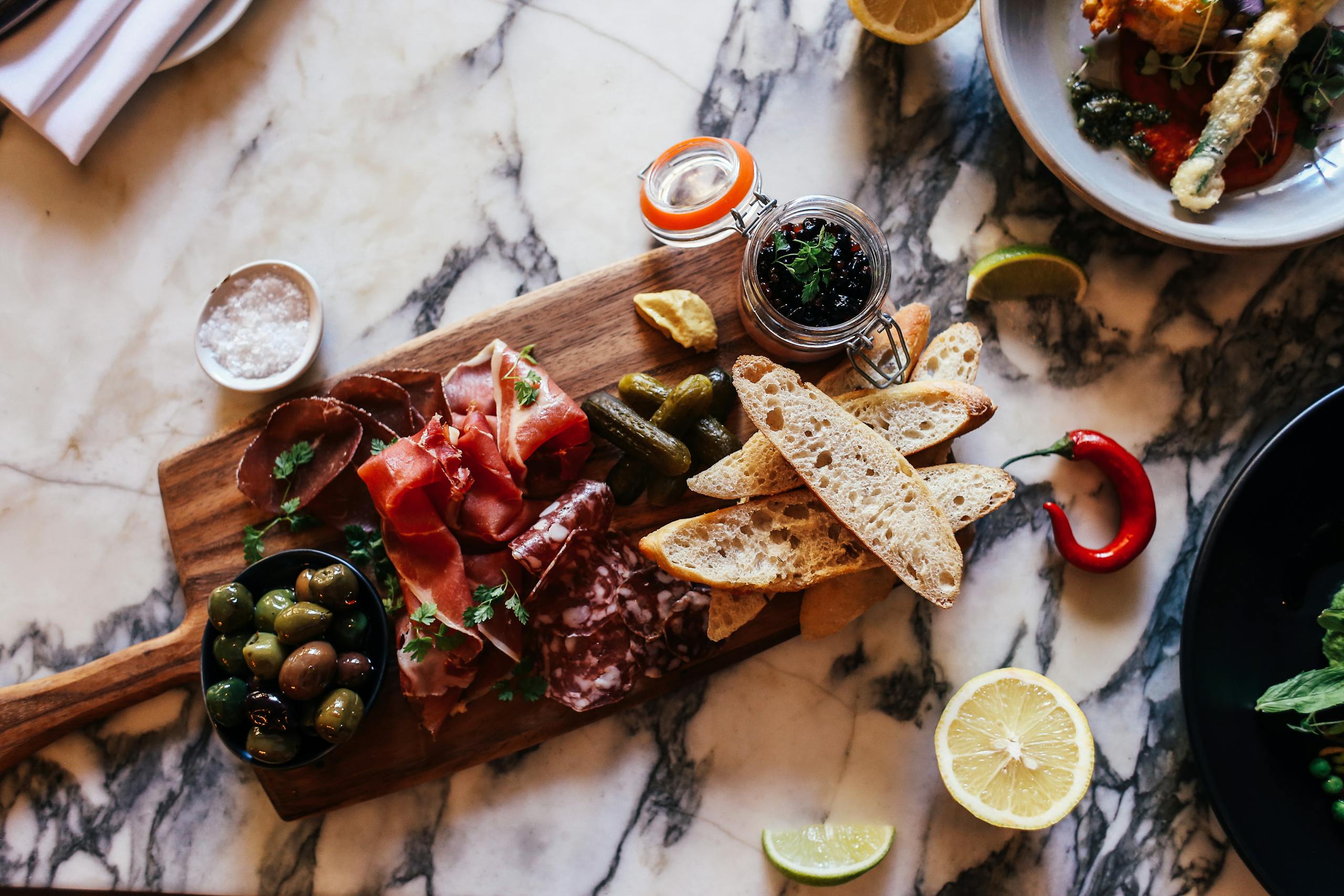 Mediterranean mezze platter with olives, cured meats, and flatbread on a rustic table – gluten-free, gut-friendly appetiser idea